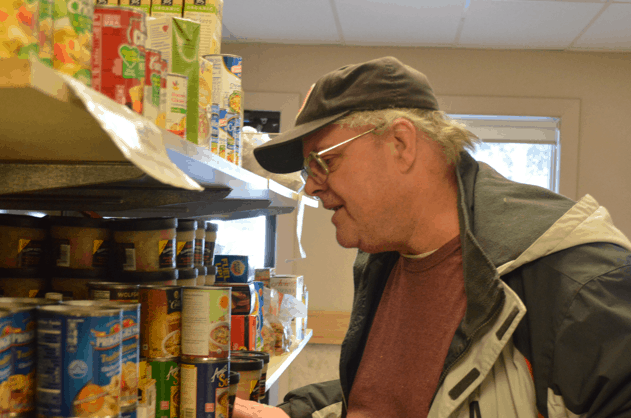 Man looking at shelves of food pantry