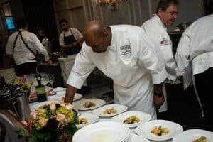 Chef putting finishing touches on a plate of food