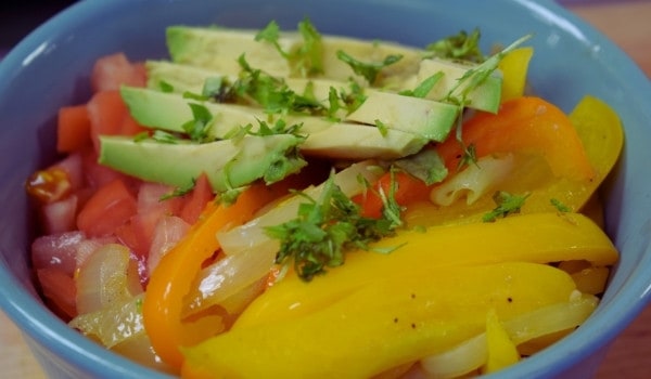 Avocado, tomato, bell pepper and cilantro in a bowl