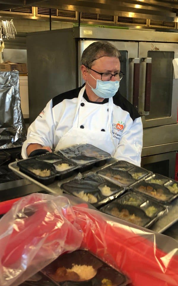 Chef loading sealed meal kits into a box