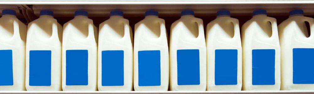 Milk containers lined up on a shelf