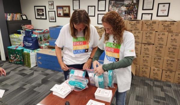 Two women putting together diaper donations