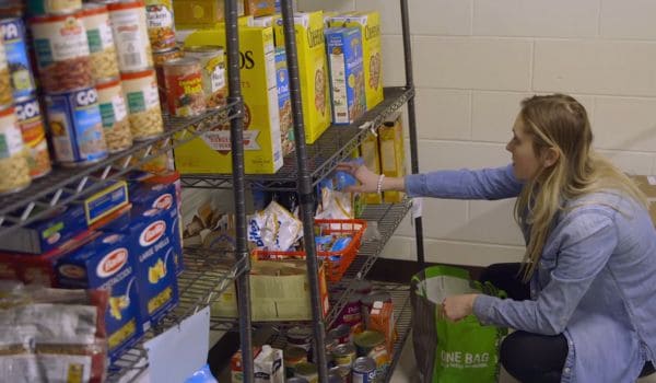 Person selecting food from shelves at a food pantry